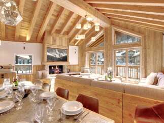 Experience luxury living in this stunning chalet, featuring a cozy fireplace and a spacious living area.