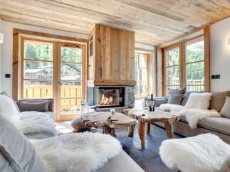Experience the warmth of this stunning living room, featuring a cozy fireplace and rustic wooden accents.