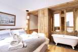 Experience luxury and comfort in this stunning bedroom featuring a cozy bed and a spa-like bathroom.