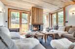 Experience the warmth of this stunning living room, featuring a cozy fireplace and rustic wooden accents.