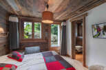 Experience rustic charm in this cozy bedroom featuring a stunning wooden ceiling and walls.