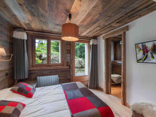 Experience rustic charm in this cozy bedroom featuring a stunning wooden ceiling and walls.