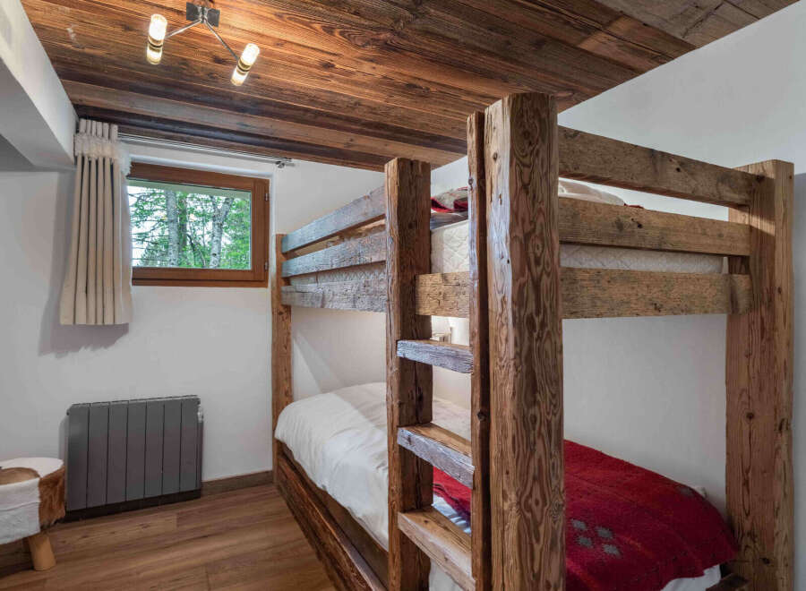 This charming bedroom features a rustic bunk bed, perfect for accommodating guests or family members.