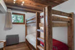 This charming bedroom features a rustic bunk bed, perfect for accommodating guests or family members.
