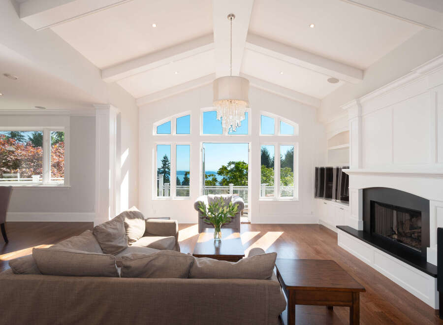 Experience luxury living in this stunning home featuring a bright and airy living room with soaring ceilings and expansive windows.
