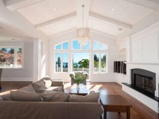 Experience luxury living in this stunning home featuring a bright and airy living room with soaring ceilings and expansive windows.