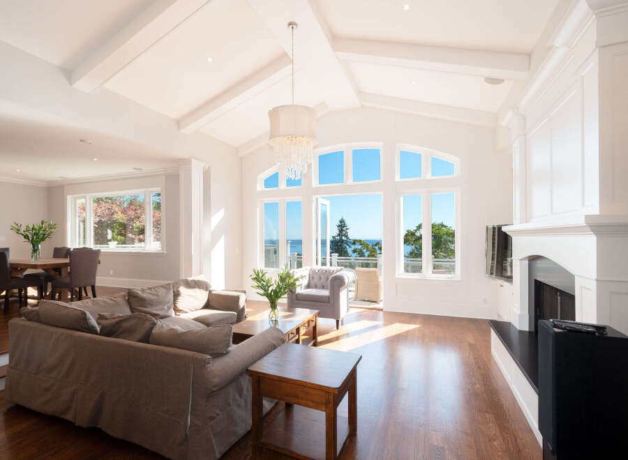 Experience luxury living in this stunning home featuring a bright and airy living room with soaring ceilings and expansive windows.