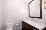 This elegant bathroom features a dark wood vanity with a marble countertop, offering a luxurious feel.
