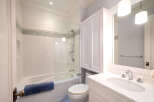 Step into this beautifully designed bathroom, featuring a pristine white vanity and a sleek, modern sink.