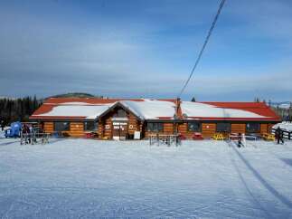 Nestled in a snowy landscape, this charming property offers a cozy retreat.