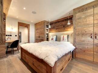 This stunning bedroom showcases rustic elegance with its wooden accents and cozy ambiance.