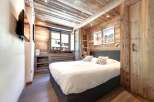 Experience the charm of this cozy bedroom, featuring rustic wooden walls and ceiling that create a warm and inviting atmosphere.