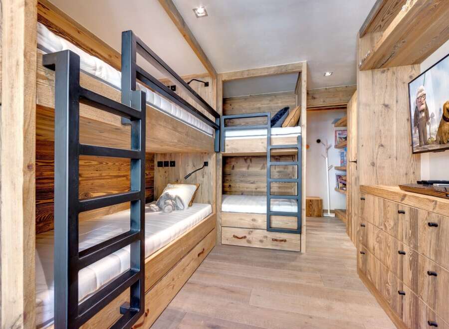 This cozy bedroom features custom-built bunk beds with a rustic wooden design, perfect for a family getaway.
