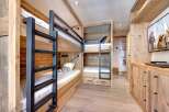 This cozy bedroom features custom-built bunk beds with a rustic wooden design, perfect for a family getaway.
