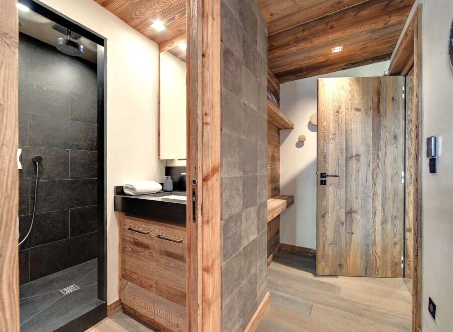 This stunning property boasts a luxurious bathroom with a modern shower and sleek black tiles.