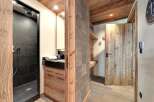 This stunning property boasts a luxurious bathroom with a modern shower and sleek black tiles.