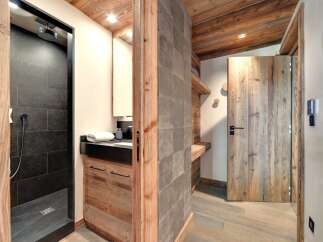 This stunning property boasts a luxurious bathroom with a modern shower and sleek black tiles.