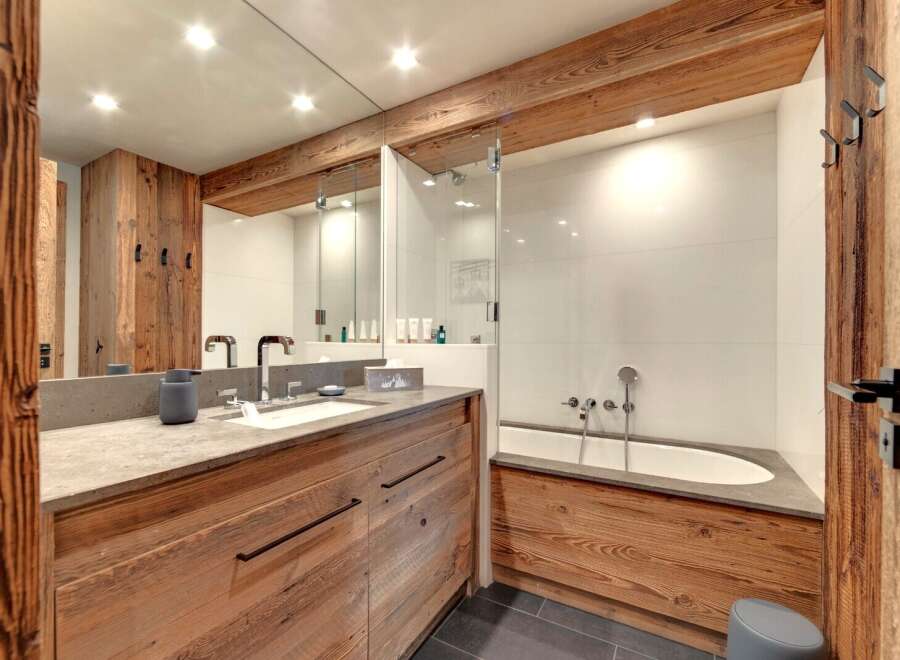 Experience luxury in this stunning bathroom featuring rustic wooden accents and modern design.