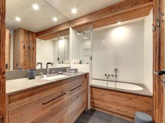 Experience luxury in this stunning bathroom featuring rustic wooden accents and modern design.