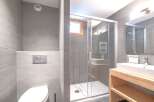 Step into a modern bathroom oasis, featuring sleek gray tile and a glass-enclosed shower.