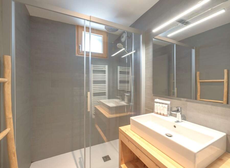 Step into this modern bathroom, featuring a sleek glass shower enclosure and contemporary design.