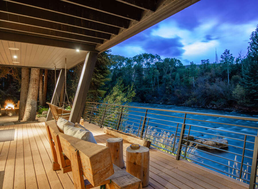 Experience luxury living with this stunning property featuring a spacious deck overlooking a serene river.