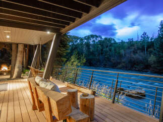 Experience luxury living with this stunning property featuring a spacious deck overlooking a serene river.