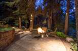 Enjoy evenings outdoors in this stunning backyard oasis, featuring a cozy fire pit and comfortable seating.