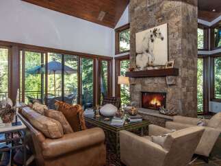 Experience luxury living in this stunning property featuring a cozy fireplace and expansive windows that flood the space with natural light.