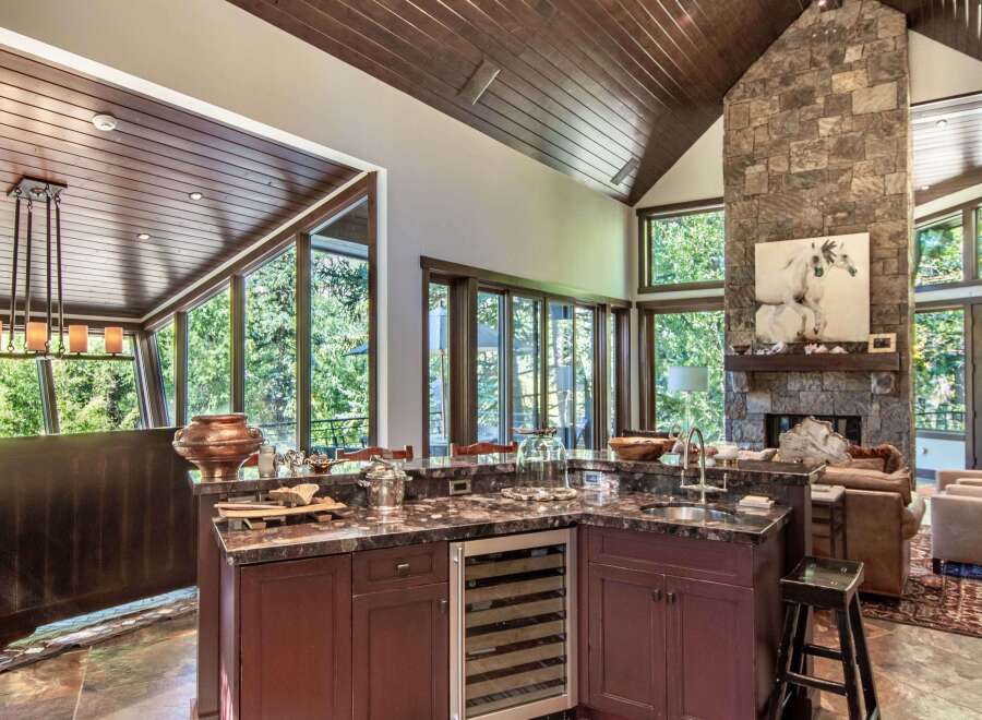 This stunning kitchen boasts a luxurious design with a granite countertop and a built-in wine cooler.