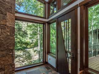 This stunning property boasts a unique architectural design, featuring expansive windows that frame breathtaking views of the surrounding natural beauty.
