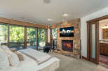 Experience luxury living in this stunning bedroom featuring a cozy fireplace and a large flat-screen TV, perfect for relaxing evenings.
