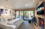 Experience luxury living in this stunning bedroom featuring a cozy fireplace and a large-screen TV for entertainment.