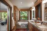 This luxurious bathroom boasts a stunning stone accent wall and a deep soaking tub, creating a spa-like retreat.