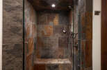 Step into luxury with this stunning shower featuring exquisite stone tile work.