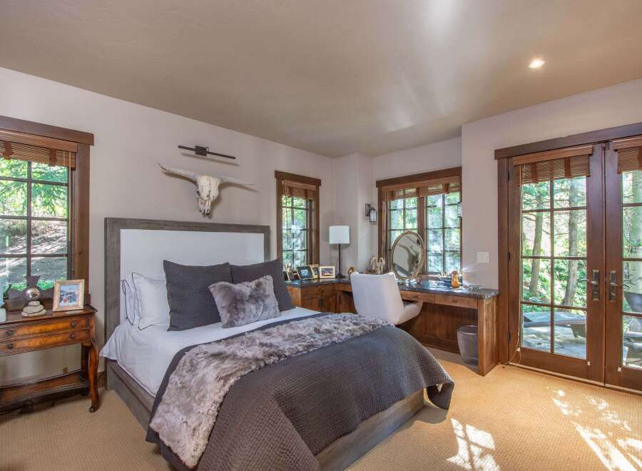 Experience luxury in this stunning bedroom featuring a cozy bed adorned with plush pillows and a faux fur throw.