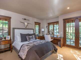 Experience luxury in this stunning bedroom featuring a cozy bed adorned with plush pillows and a faux fur throw.