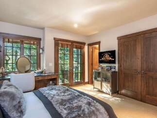 This luxurious bedroom boasts a serene ambiance with its plush bedding and elegant decor.