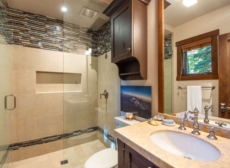 Step into luxury with this stunning bathroom featuring a modern glass shower and elegant vanity.