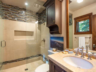 Step into luxury with this stunning bathroom featuring a modern glass shower and elegant vanity.