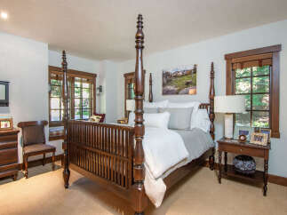 Step into luxury with this stunning bedroom featuring a grand four-poster bed as the centerpiece.