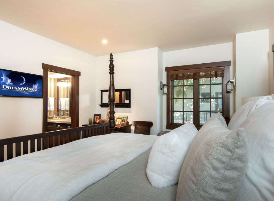 Experience luxury in this stunning bedroom, featuring a cozy bed with plush pillows and a soft blanket.