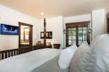 Experience luxury in this stunning bedroom, featuring a cozy bed with plush pillows and a soft blanket.