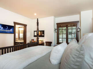 Experience luxury in this stunning bedroom, featuring a cozy bed with plush pillows and a soft blanket.