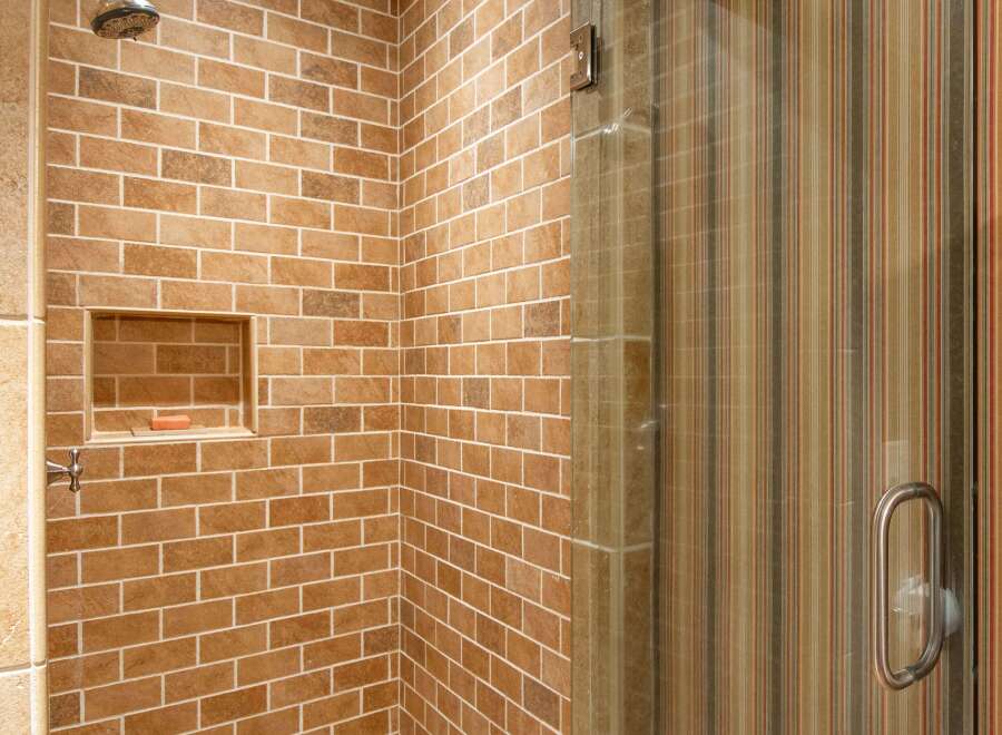 Step into a beautifully designed bathroom featuring a stunning brick-style tiled shower.
