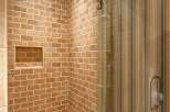 Step into a beautifully designed bathroom featuring a stunning brick-style tiled shower.