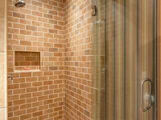 Step into a beautifully designed bathroom featuring a stunning brick-style tiled shower.