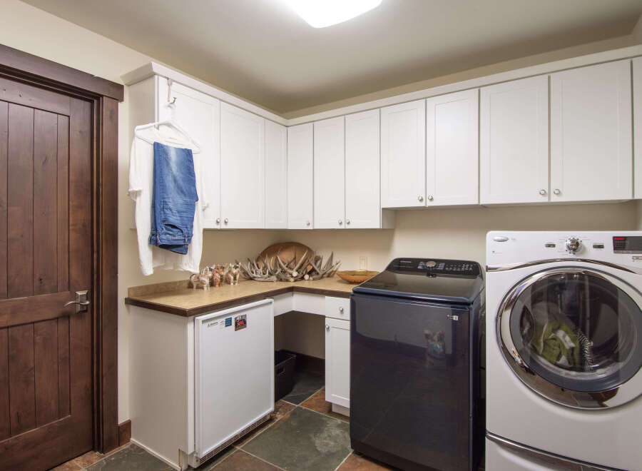 This laundry room features a modern design with ample storage space.