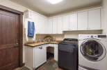 This laundry room features a modern design with ample storage space.