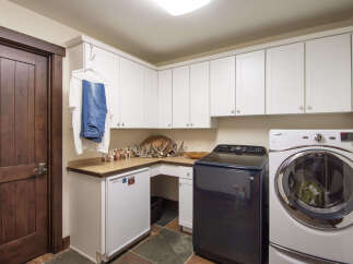 This laundry room features a modern design with ample storage space.